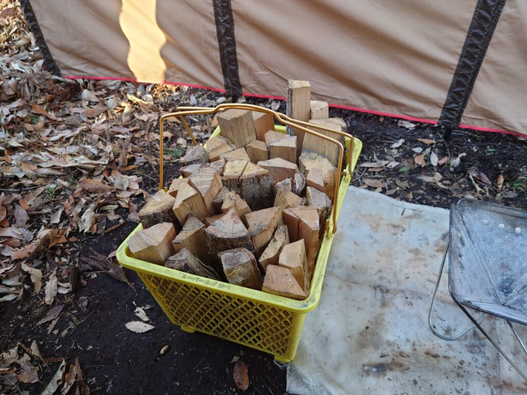 キャンプ冒険仲間のかごに入った薪