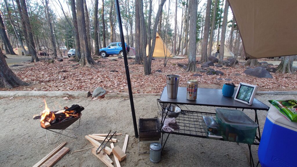 燃え始めた焚火とビール