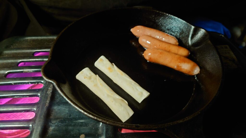 スキレットで調理中のウインナーとチーズ