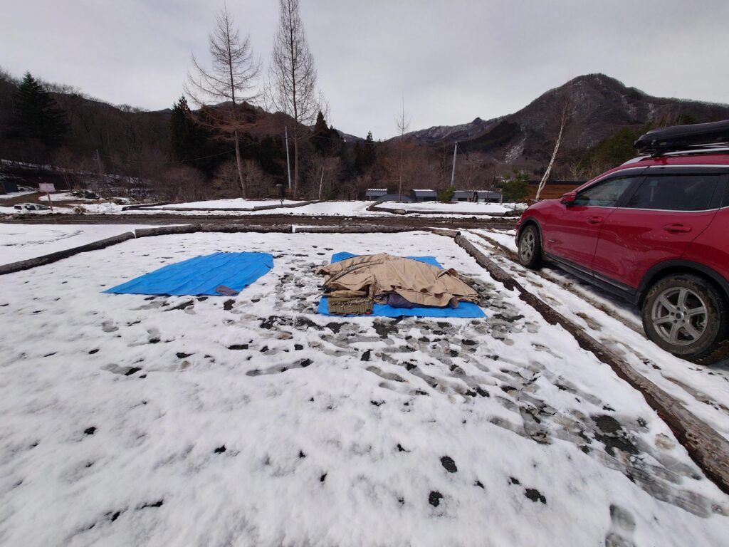 雪の上に広げたグランドシート