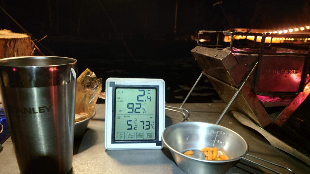 テーブルの上の温度計とシェラカップに残った柿の種
