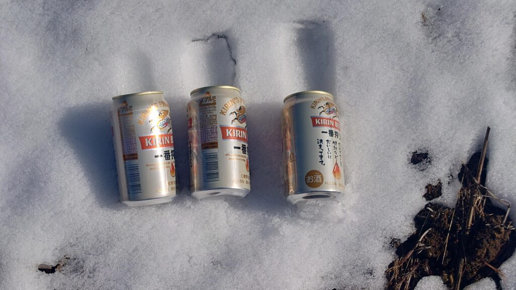 雪の上で冷却中の缶ビール