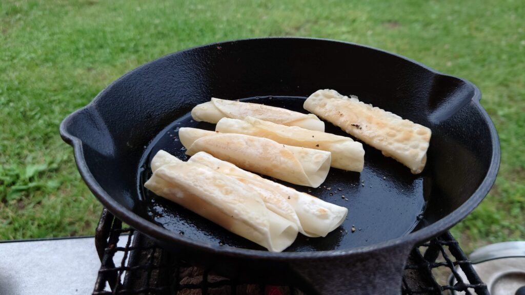 スキレットで調理したチーズの餃子の皮包み