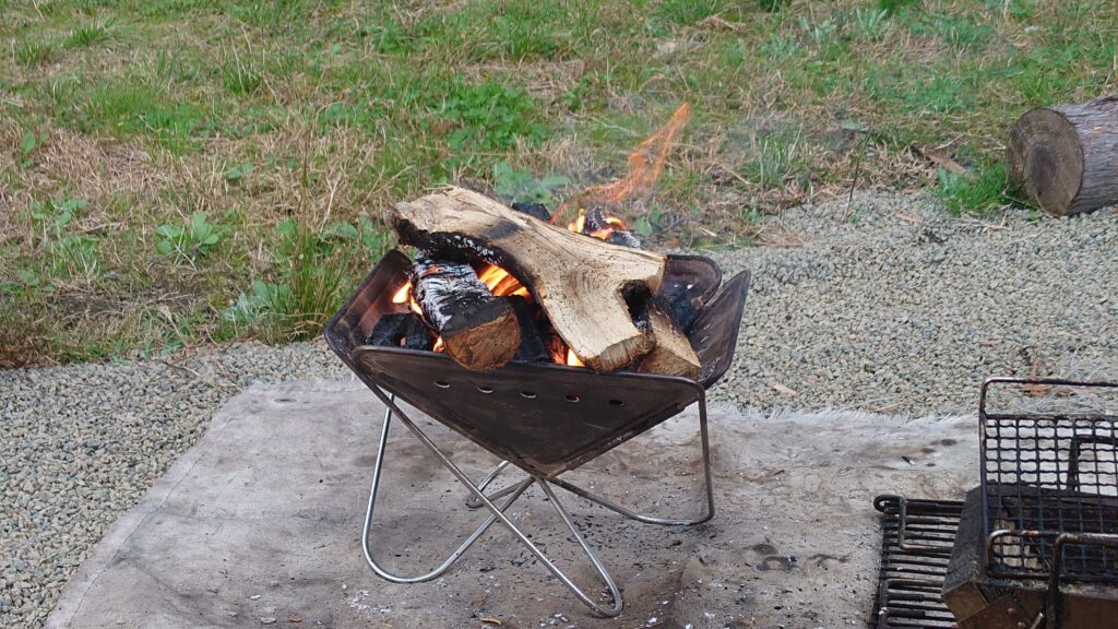 焚火の中にオガ炭を投入