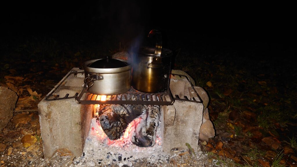 焚火にかけた鍋とケトル