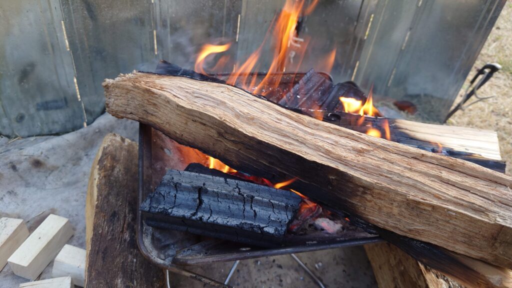 焚火台からはみ出る薪とオガ炭