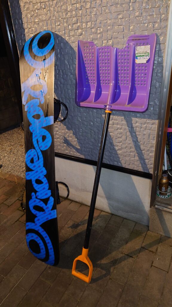 手入れをしたスノーボードと雪かきスキップ