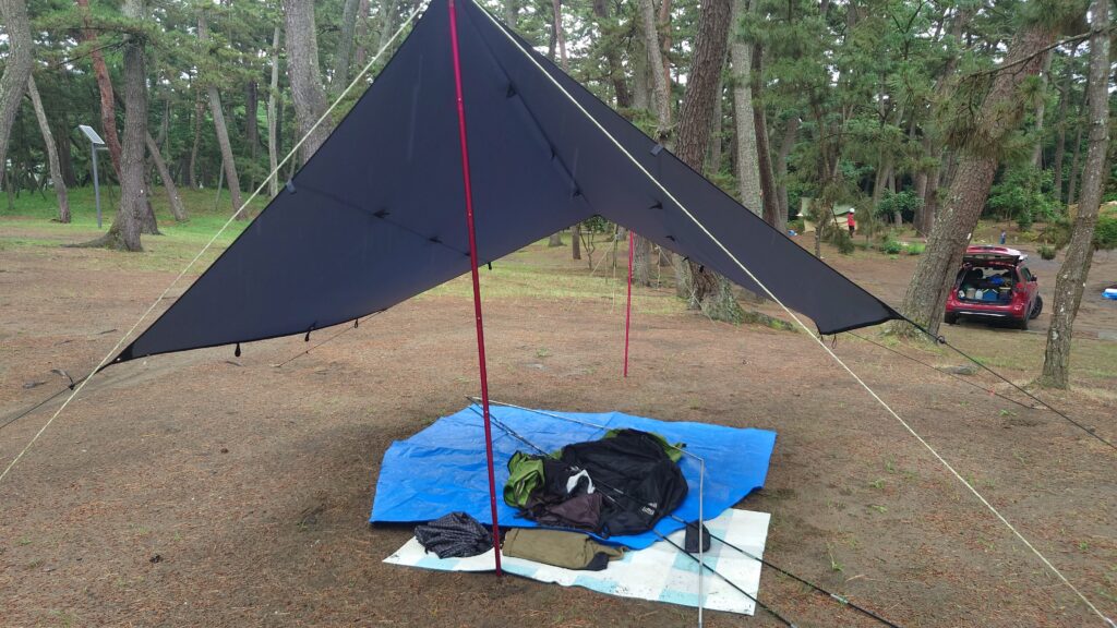 雨の中設営したタープの下でテントを展開