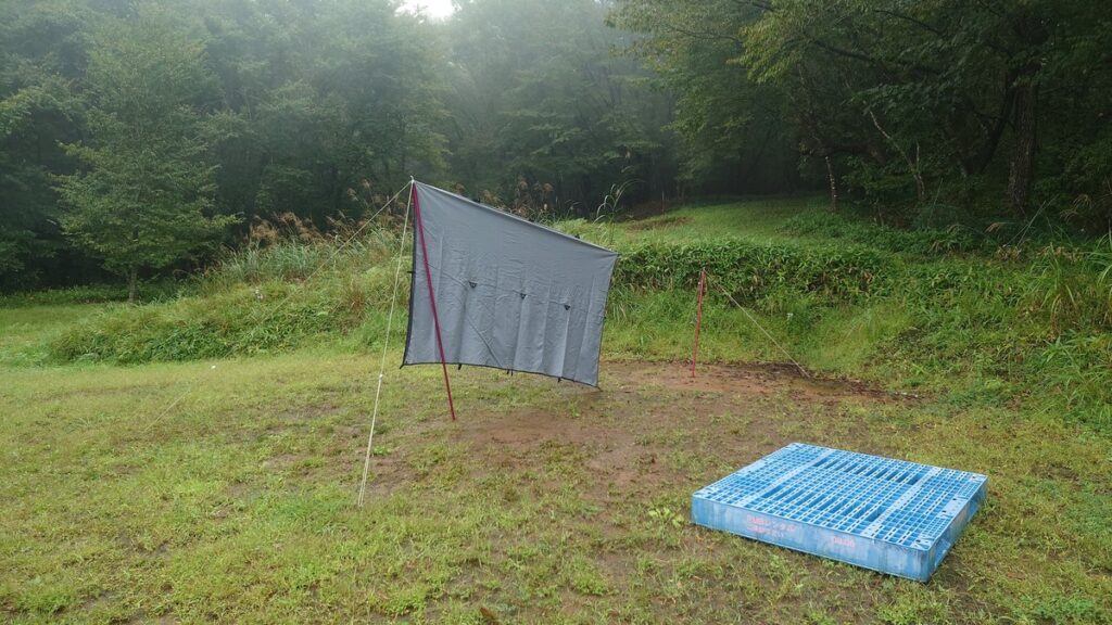 雨の星空キャンプ場最上部に設営中のタープ