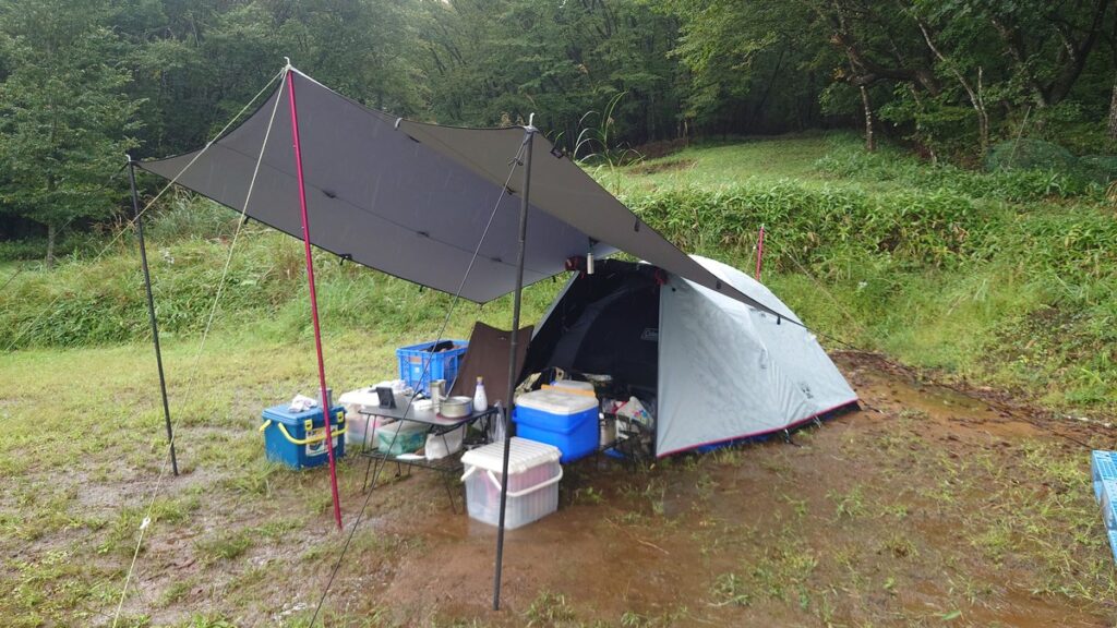 雨のタープの下に広げたキャンプサイト