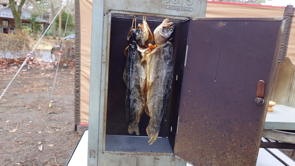 燻製機に吊したマスの冷燻