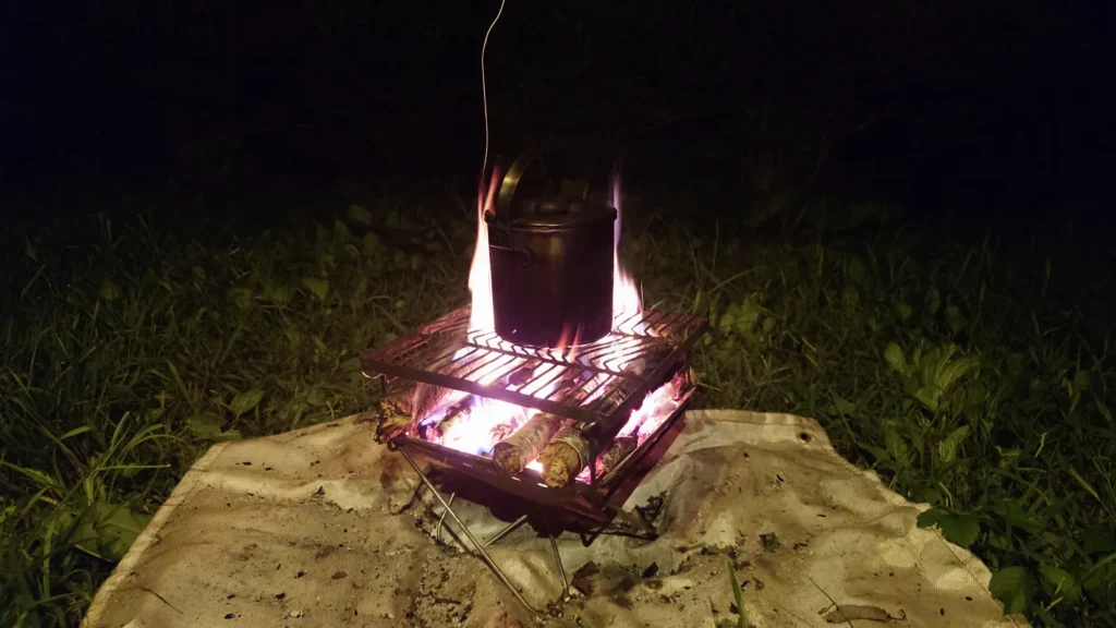 燃え上がる焚き火の炎とヤカン
