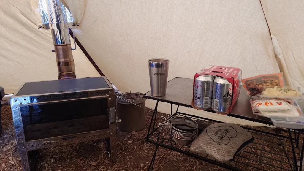 テント内の薪ストーブと缶ビール