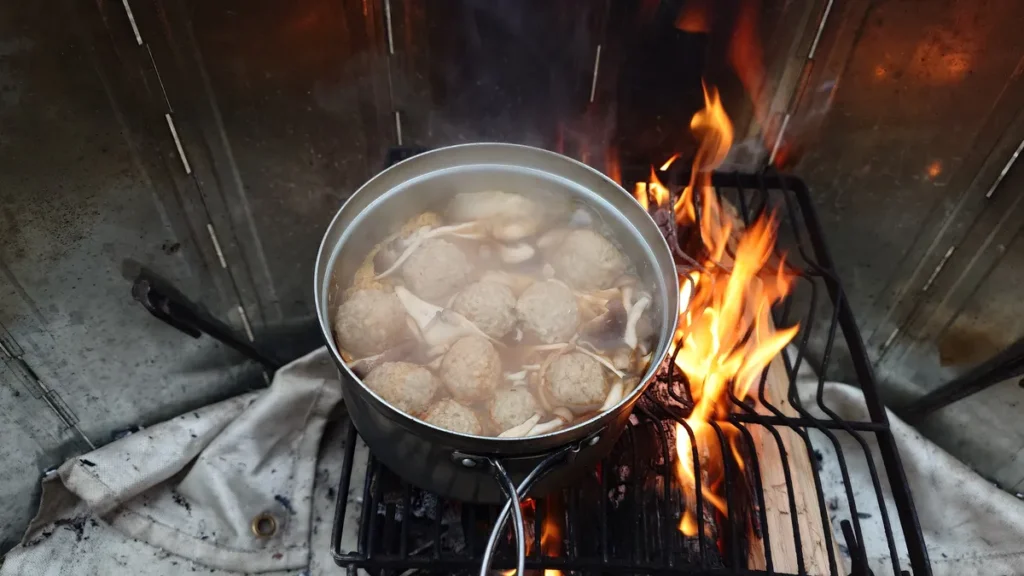 焚き火で煮込まれた鍋