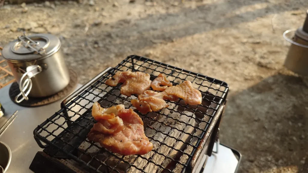 漬け込んだ鶏肉と豚肉の炭火焼き