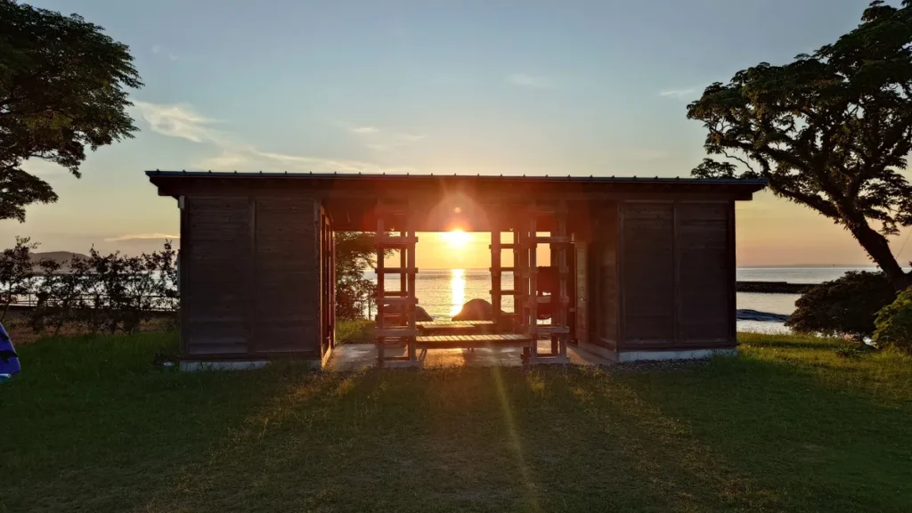 人魚の湯オートキャンプ場電源付オートサイトシャワー棟の間に沈む夕日
