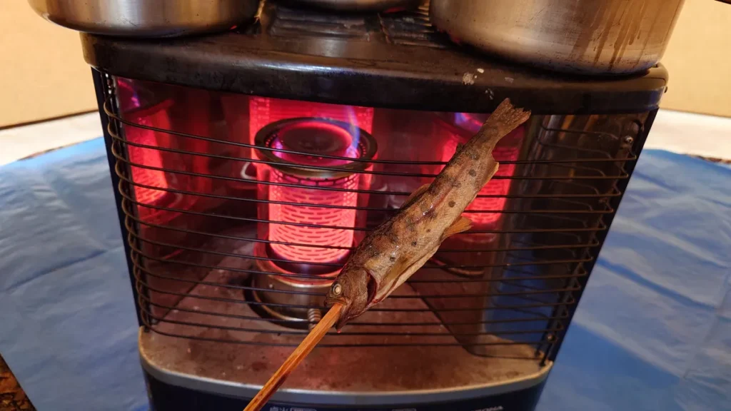 石油ストーブで温めるヤマメ