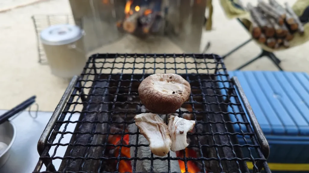 料理: 炭火で焼くシイタケと醤油を垂らした食べごろのサイン