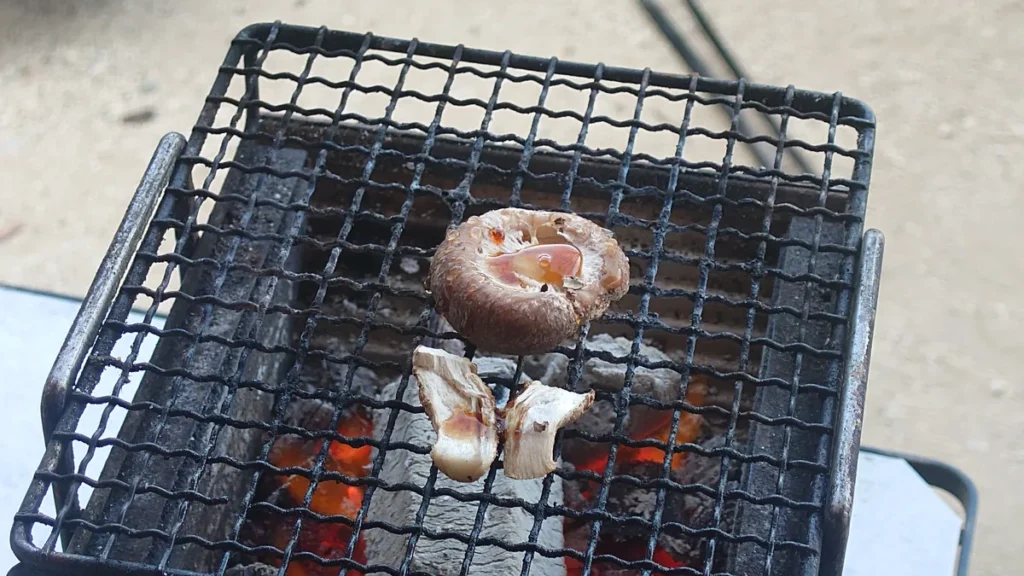 料理: 炭火で焼くシイタケと醤油を垂らした食べごろのサイン