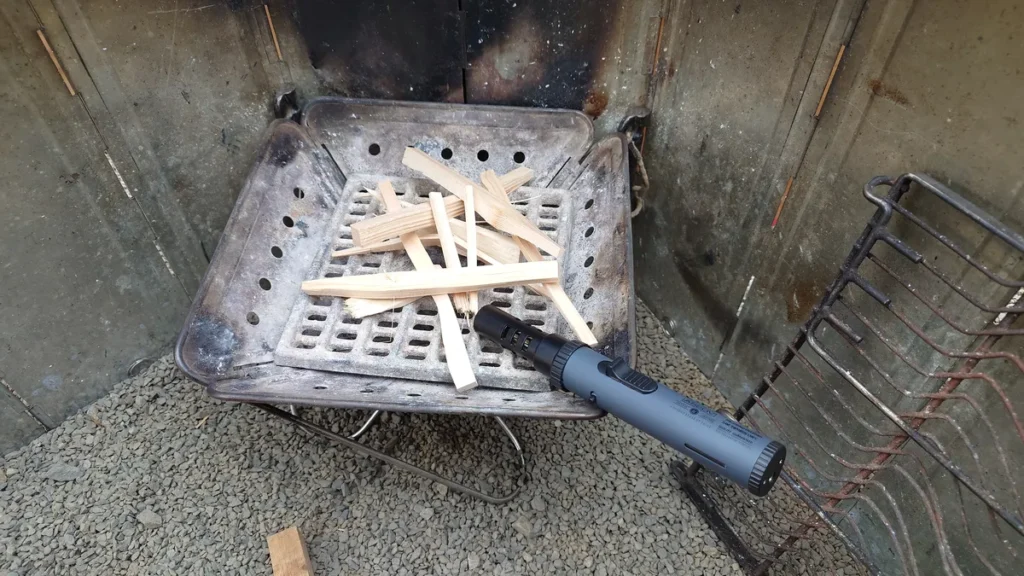 焚火台の上の焚き付け用木端とアソッブポータブルスティックバーナー