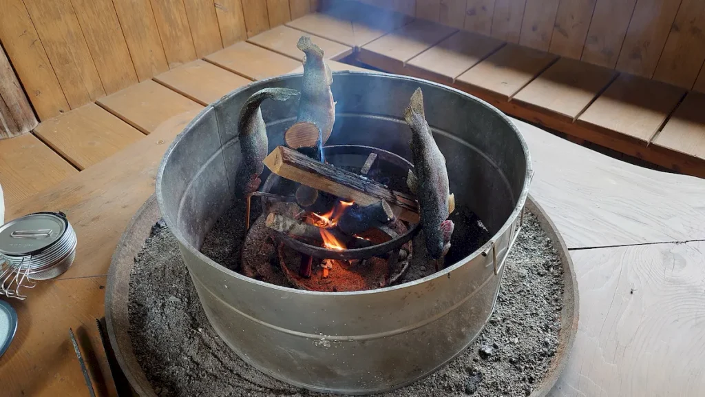 焚火に囲いを付けてマスを焼く